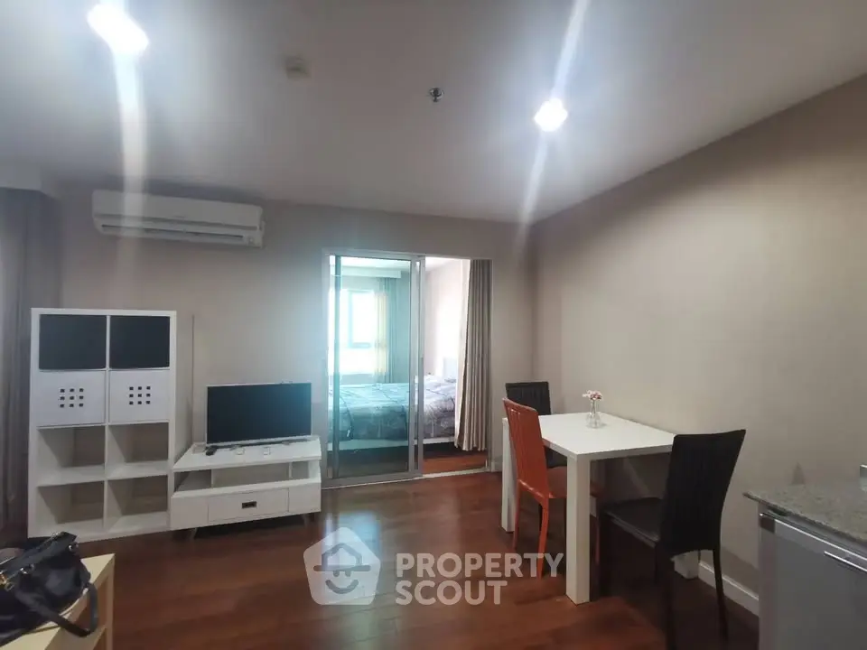 Modern apartment interior with open living and dining area featuring hardwood floors and stylish furniture.