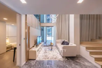 Modern living room with high ceilings and elegant staircase in luxury apartment