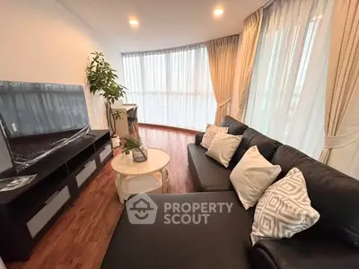 Spacious living room with modern decor and large windows offering natural light.
