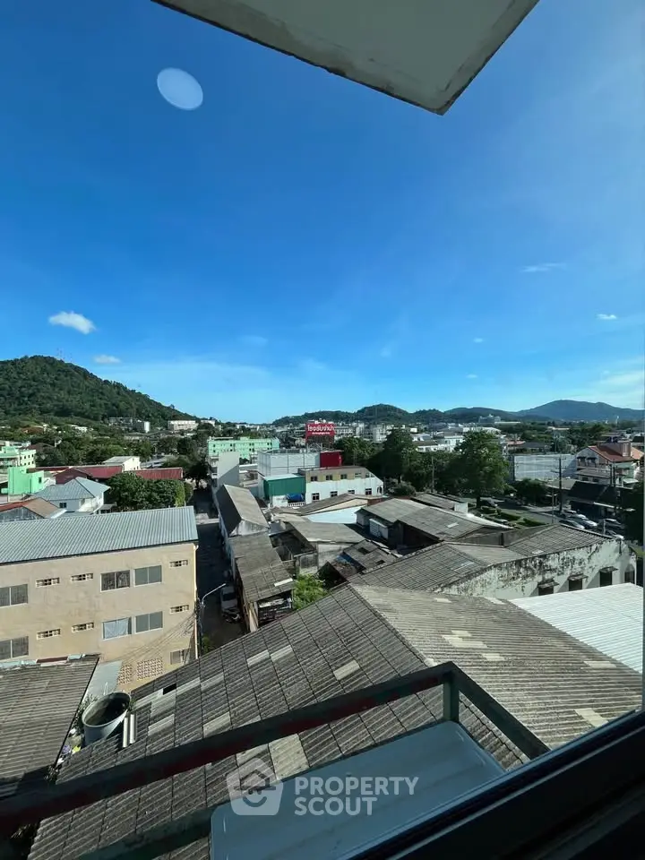 Scenic cityscape view from a high-rise building window showcasing urban and natural landscapes.