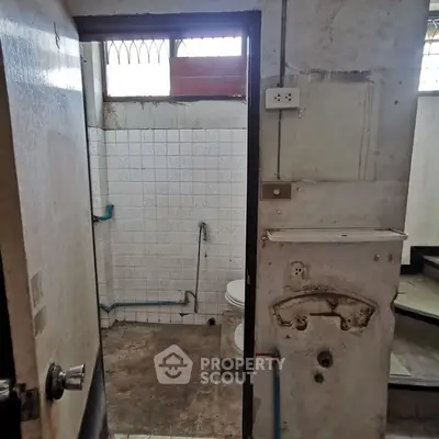 Rustic bathroom with exposed pipes and unfinished walls