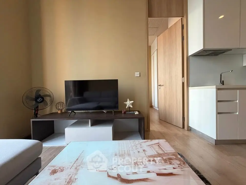 Modern living room with sleek TV stand and open kitchen layout, perfect for urban living.