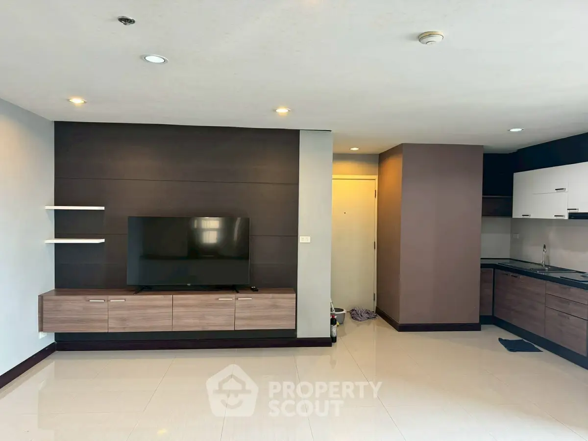 Modern living room with sleek TV unit and stylish kitchen area
