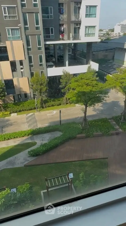Modern apartment building with lush green landscaping and clear blue sky view.
