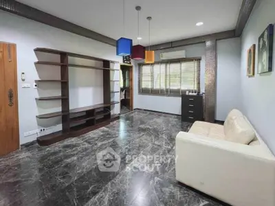 Spacious living room with modern shelving and marble flooring