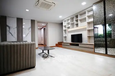 Spacious modern living room with sleek design and built-in entertainment center.