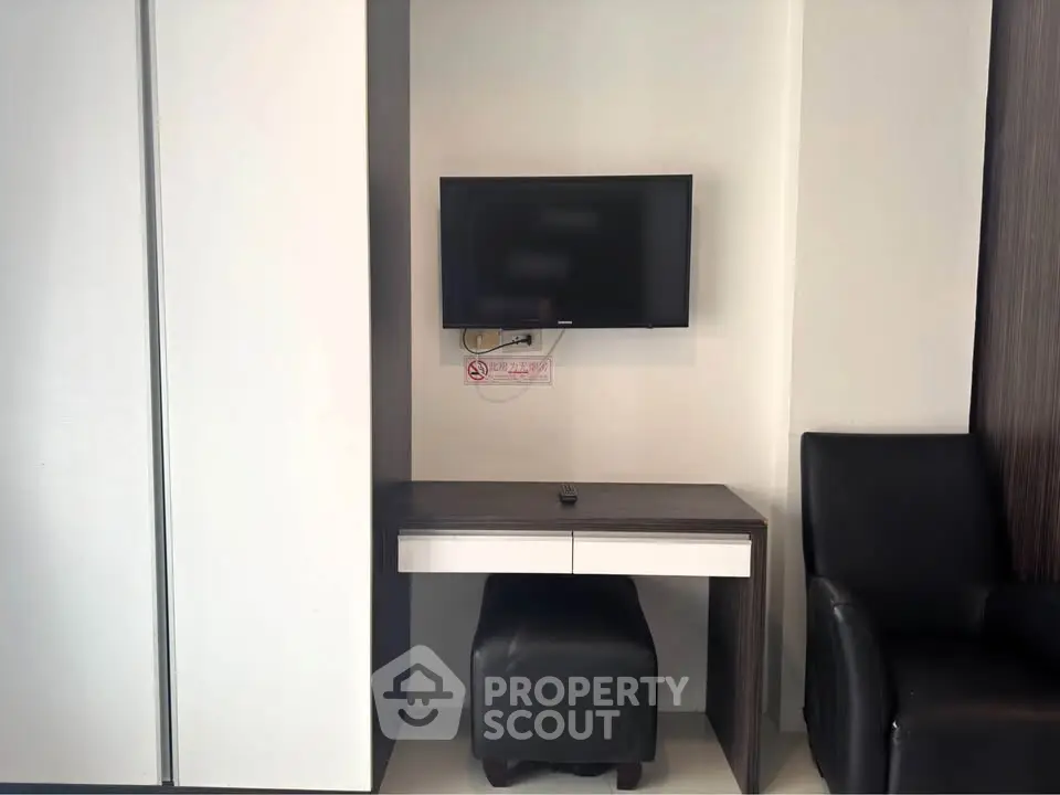 Modern living room with wall-mounted TV and sleek furniture