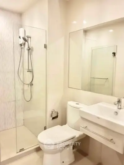 Modern bathroom with glass shower and sleek fixtures in a contemporary apartment.