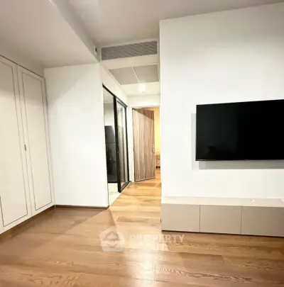 Modern living room with sleek TV setup and wooden flooring