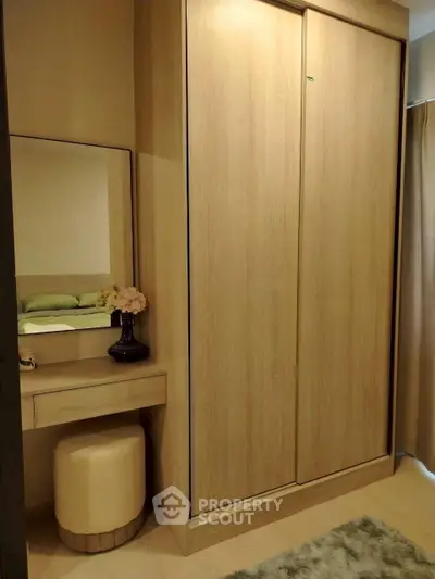Stylish bedroom with wooden wardrobe and vanity area, perfect for modern living.