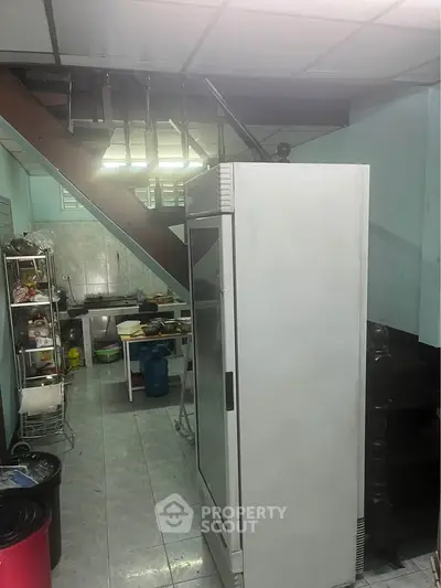 Spacious kitchen with open layout and modern appliances under a staircase, ideal for culinary enthusiasts.