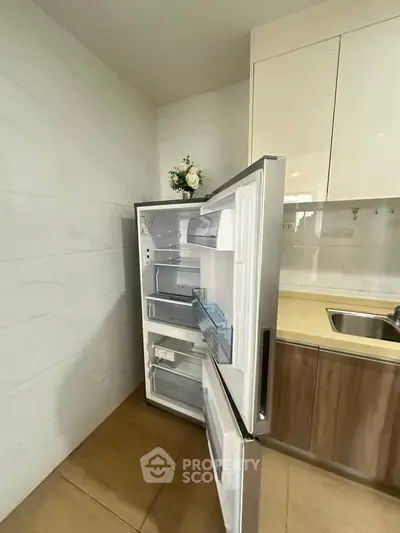 Modern kitchen with open fridge and sleek cabinetry