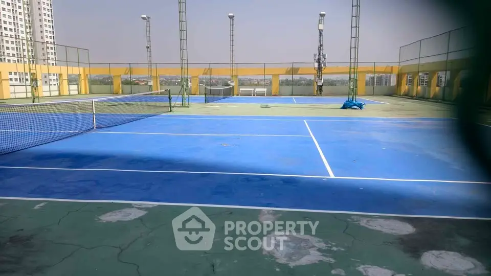 Spacious rooftop tennis court with city views, perfect for sports enthusiasts.