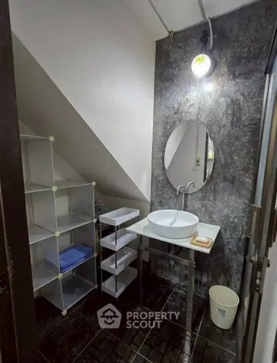 Modern bathroom with unique under-stair design and stylish fixtures