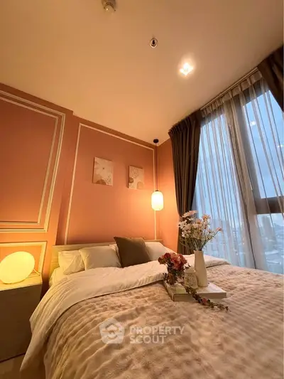Cozy bedroom with elegant decor and large window offering city views.