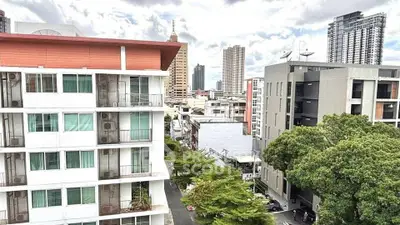 Stunning urban view from a high-rise apartment showcasing modern architecture and lush greenery.