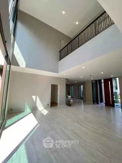 Spacious modern living room with high ceilings and elegant balcony railing