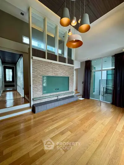 Spacious modern living room with hardwood floors and stylish lighting in a luxury apartment.
