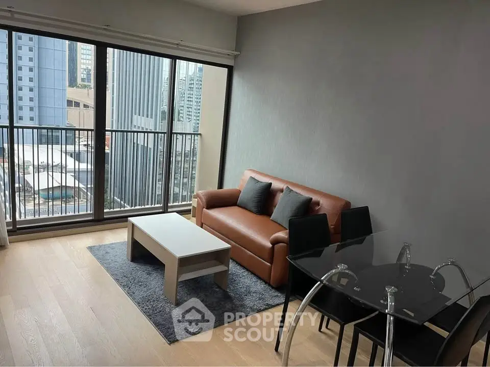 Modern living room with city view, featuring sleek furniture and large windows.