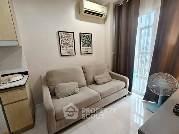 Cozy living room with modern sofa and air conditioning, featuring natural light and stylish decor.