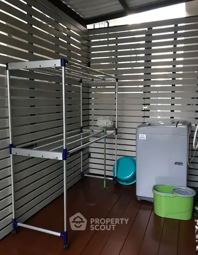 Modern laundry area with washing machine and drying rack in stylish outdoor setting