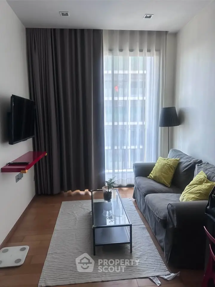 Cozy living room with modern decor, featuring a comfortable sofa, stylish lamp, and wall-mounted TV.
