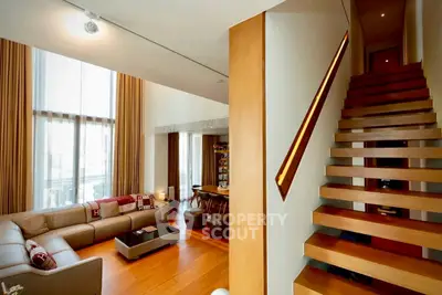 Luxurious modern living room with high ceilings and elegant staircase
