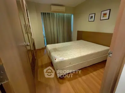 Cozy bedroom with wooden flooring and natural light, featuring a comfortable bed and stylish decor.