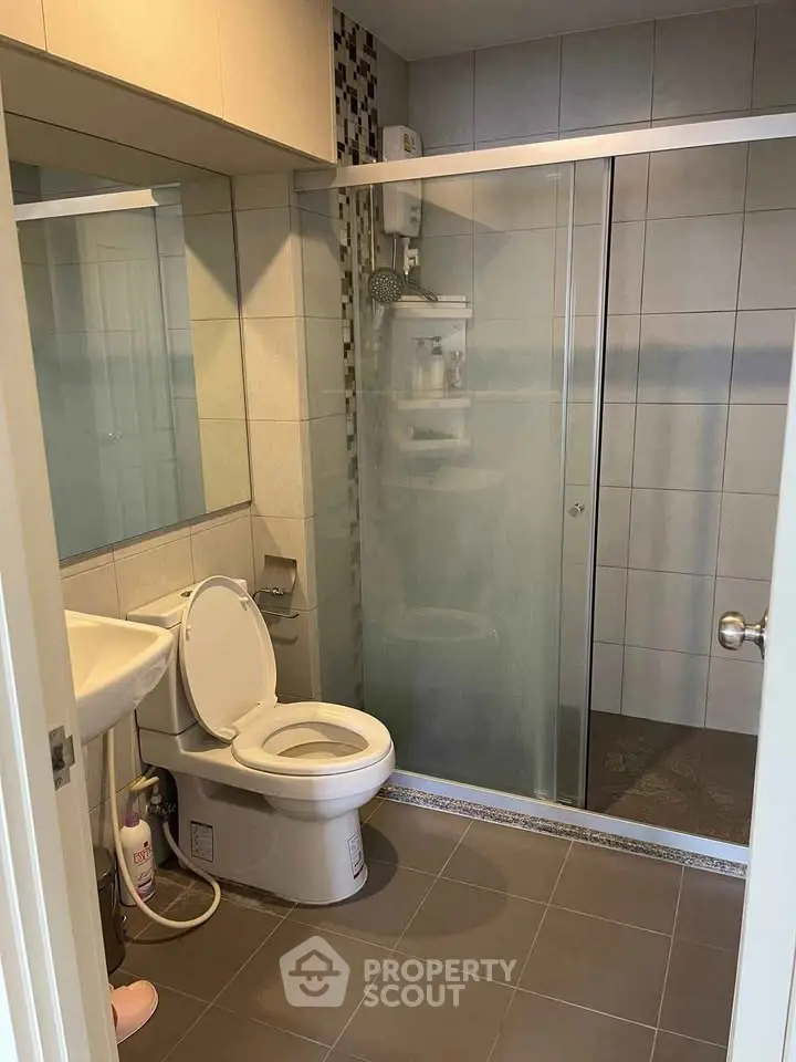 Modern bathroom with glass shower enclosure and sleek fixtures