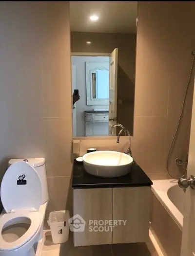 Modern bathroom with sleek fixtures and neutral tones, featuring a bathtub and stylish vanity.