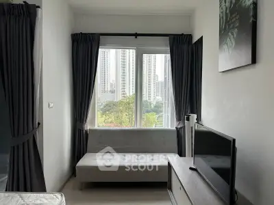 Modern living room with city view, featuring a sleek sofa and flat-screen TV, perfect for urban living.