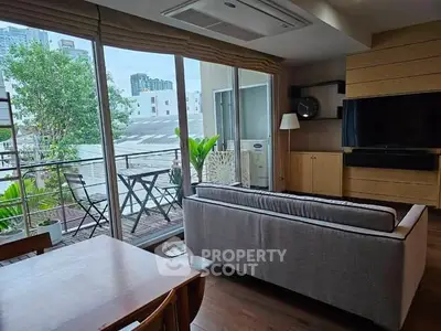 Modern living room with large windows and balcony view in urban setting.