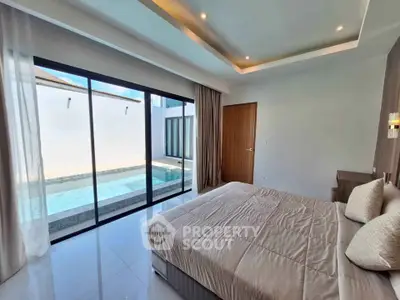 Luxurious bedroom with pool view and modern design, featuring large windows and elegant decor.