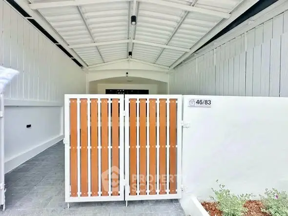Modern gated entrance with sleek design and white accents in a residential property.