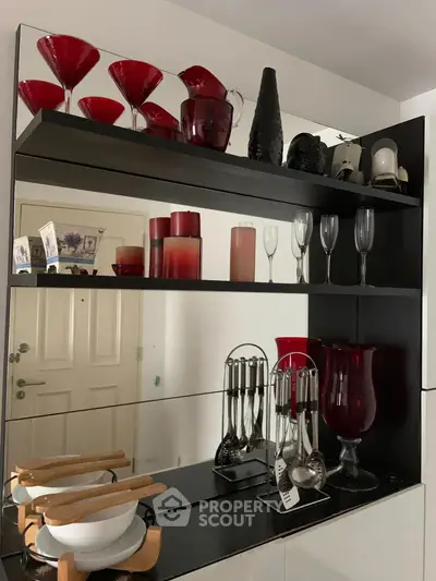 Stylish kitchen with elegant red and black decor, featuring modern shelving and glassware.