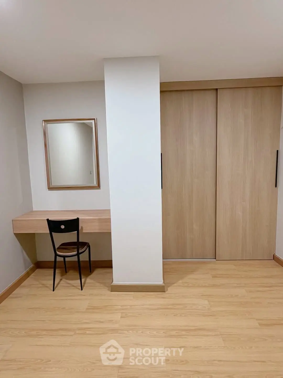 Minimalist study area with wooden desk and chair, perfect for a home office setup.