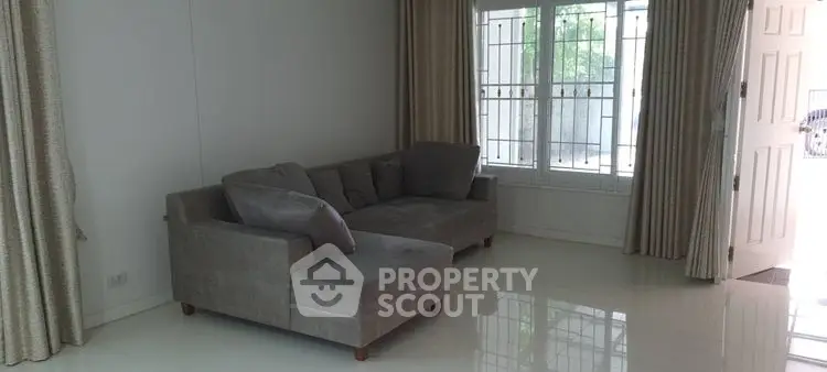 Spacious living room with modern gray sofa and large window