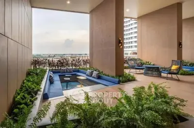 Luxurious open-air lounge with modern seating and lush greenery, offering stunning views.