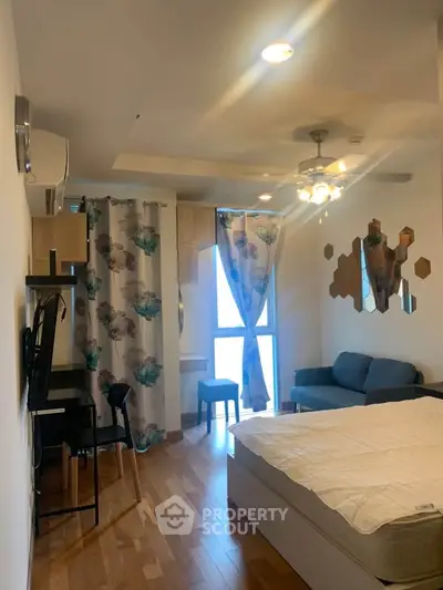 Cozy bedroom with modern decor, featuring a comfortable bed, stylish curtains, and a small seating area.