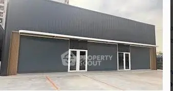 Modern commercial building with sleek facade and ample parking space.