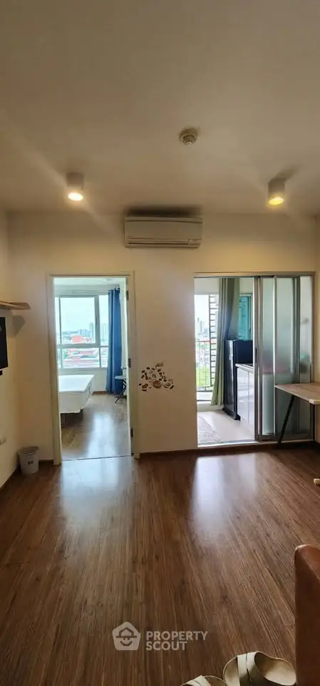 Spacious apartment interior with wooden flooring and balcony view