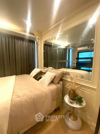 Luxurious bedroom with elegant decor and mirrored wall for spacious feel