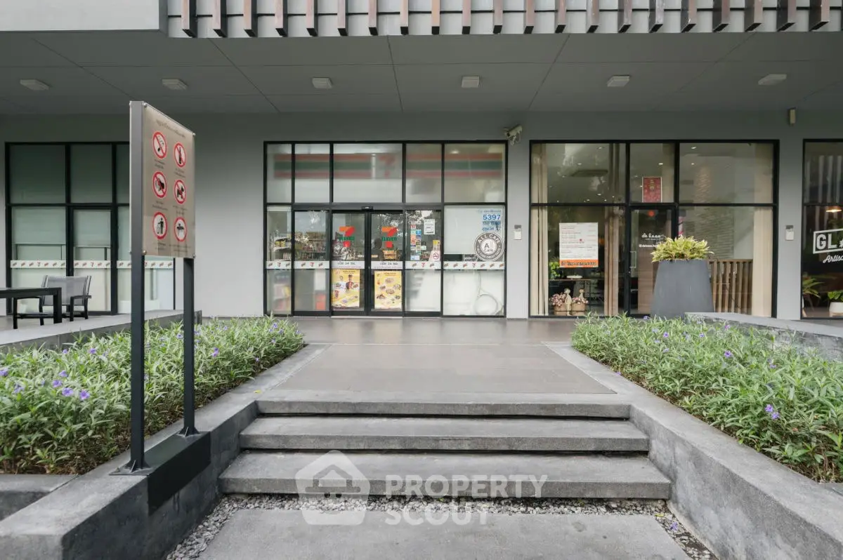 Modern building entrance with landscaped steps and large glass windows.
