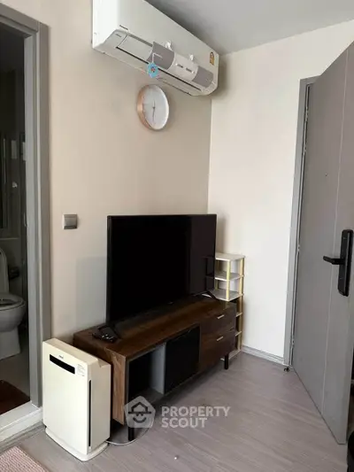 Modern living room with air conditioning and sleek TV setup, perfect for cozy urban living.