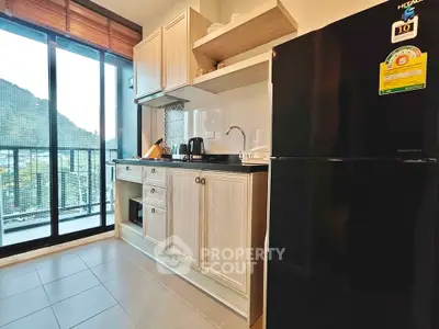 Modern kitchen with sleek black fridge and mountain view from balcony