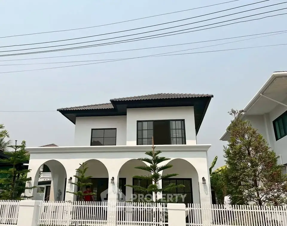 Elegant two-story white house with modern design and lush greenery