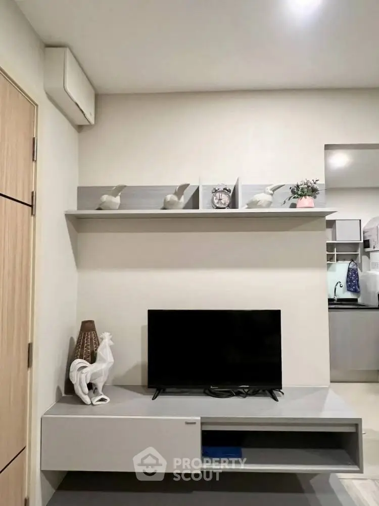Modern living room with sleek TV stand and decorative shelving in stylish apartment.