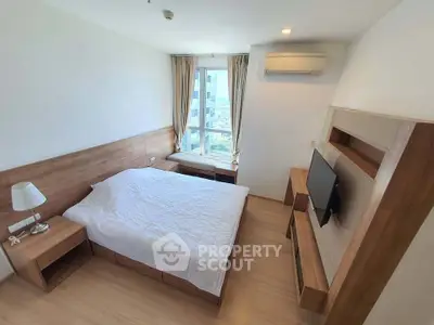 Modern bedroom with wooden furniture and city view window in a high-rise apartment.
