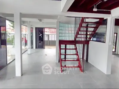 Spacious modern interior with sleek staircase and glass block wall, ideal for contemporary living.