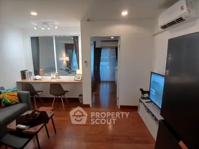 Modern living room with sleek furniture and open layout, featuring a cozy study nook and stylish decor.